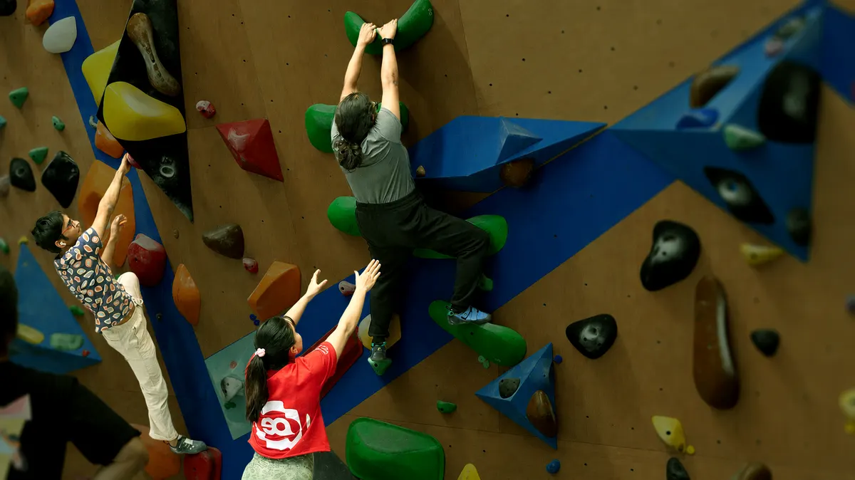 A first-timer trying bouldering with an instructor at Equilibrium